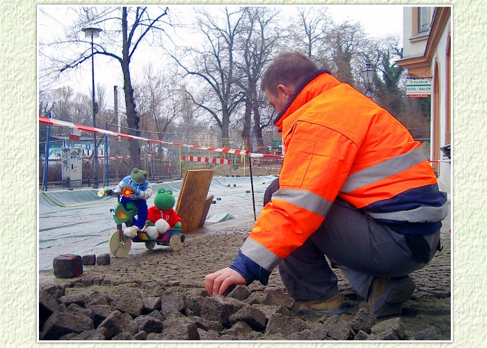 Kurti und Mondi beobachten die Arbeiter, der mit Pflasterarbeiten am Gehweg beschäftigt sind. Verwendet werden Mosaiksteine, die es auch den Freunden ermöglicht, mit ihrem Dreirad den Weg zu passieren. Auch hier werden Kurti und Mondi wieder vorbei schauen. Ganz besonders freuen sie sich auf die Treppenanlage mit Holzsitzelementen, die im Sommer zum Verweilen einladen sollen.